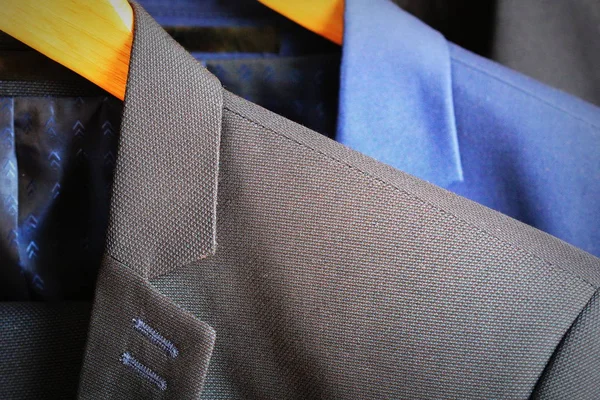 Row of mens suits hanging on rack — Stock Photo, Image