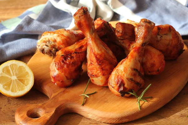 Pernas de frango grelhadas na placa de corte.Fundo de jantar rústico — Fotografia de Stock