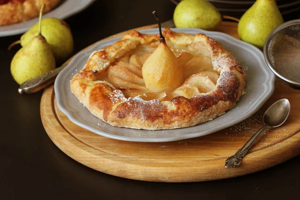 Homemade galette with pears on black background. French cuisine - Breton galette. Sweet open pie — Stock Photo, Image