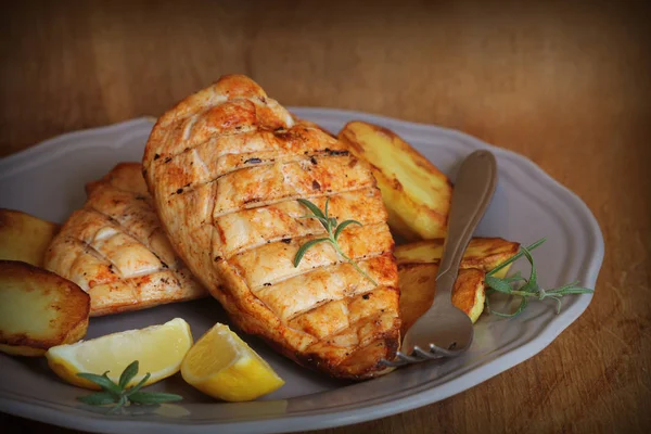 Жареная куриная грудка с жареной картошкой и лимоном — стоковое фото