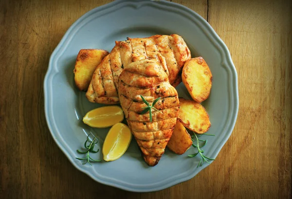 Gegrilde Kipfilet met gebakken aardappel en citroen. Bovenaanzicht — Stockfoto