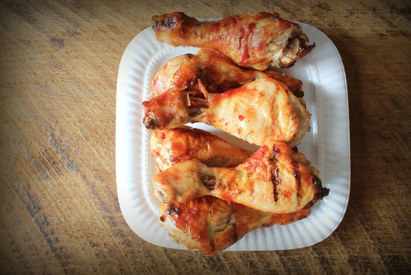 Grilled chicken legs on white plate. Rustic background — Stock Photo, Image
