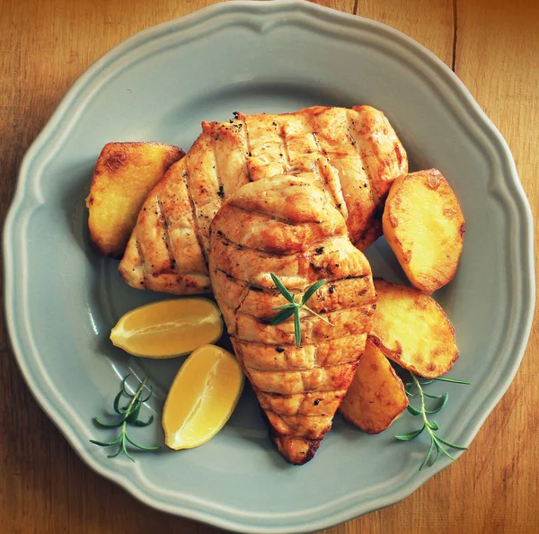 Grilled chicken breast with fried potato and lemon. Top view — Stock Photo, Image