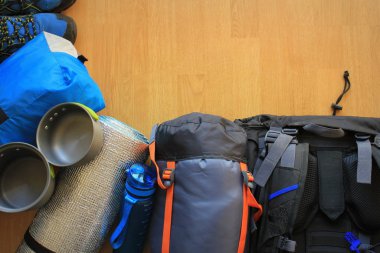 Ahşap zemin üzerinde kamp ekipmanları ile düz kompozisyon yatıyordu