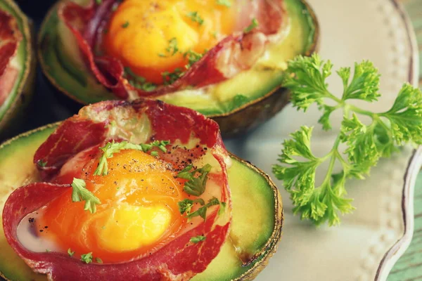 Avocado Egg Barche con pancetta su sfondo di legno Fotografia Stock