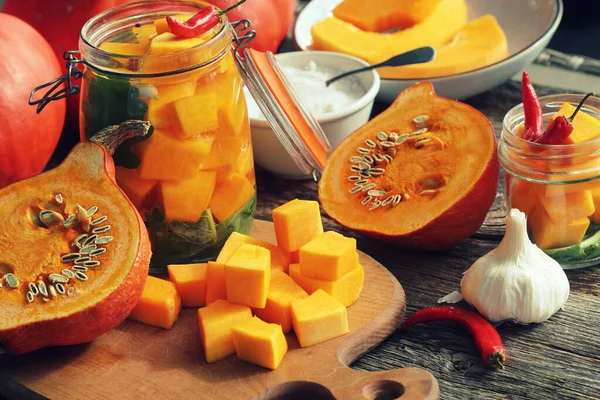 Zucca fresca fatta in casa sottaceto in un bicchiere ed erbe su un tavolo di legno — Foto Stock