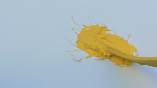 슬로우 모션 파란색과 흰색 페인트에 노란색 튄 — 비디오