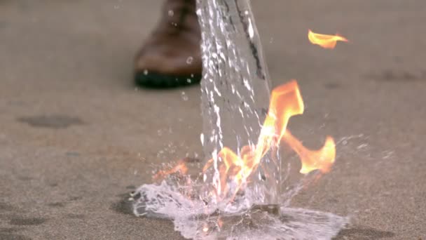 Замедленная съемка, заливающая воду в огонь — стоковое видео