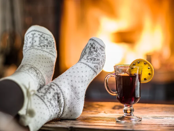 Riscaldamento e relax vicino al camino con una tazza di vino caldo . — Foto Stock