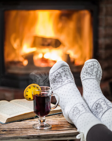 Warming and relaxing near fireplace with a cup of hot wine and a