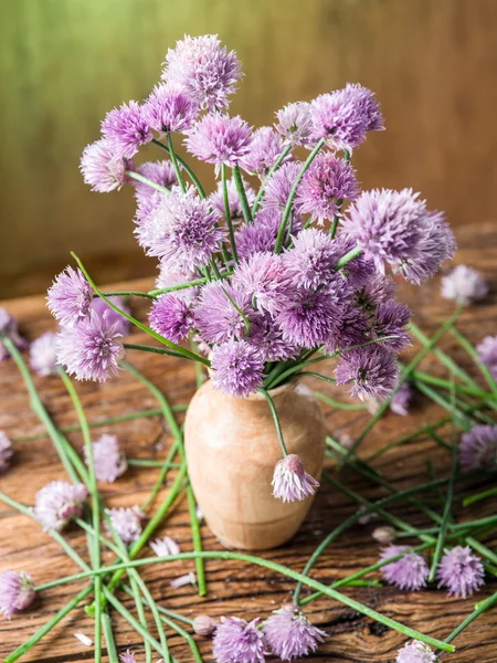 Букет з цибулевих квітів у вазі на дерев'яній тарілці — стокове фото