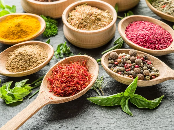 Assortment of colorful spices in the wooden spoons. — Stock Photo, Image