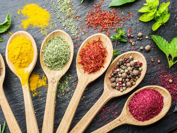 Assortment of colorful spices in the wooden spoons. — Stock Photo, Image