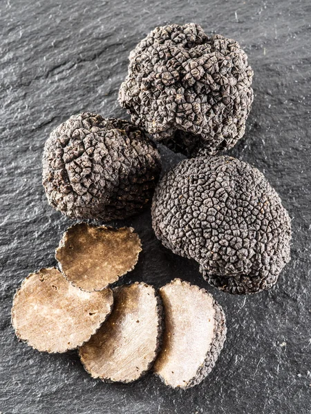 Zwarte truffels en truffel segmenten op het bord grafiet. — Stockfoto