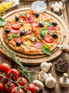 Mantar, salam ve domates pizza.