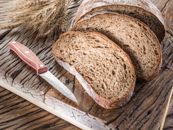 Plátky černého chleba na dřevěné prkno. — Stock fotografie