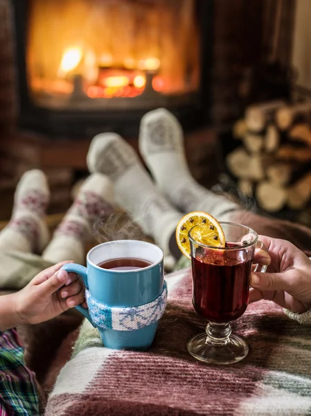 Uppvärmningen och avkopplande brasan med en kopp varm dryck. — Stockfoto