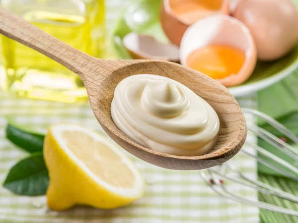 Natural mayonnaise sauce in the wooden spoon and its ingredient — Stock Photo, Image