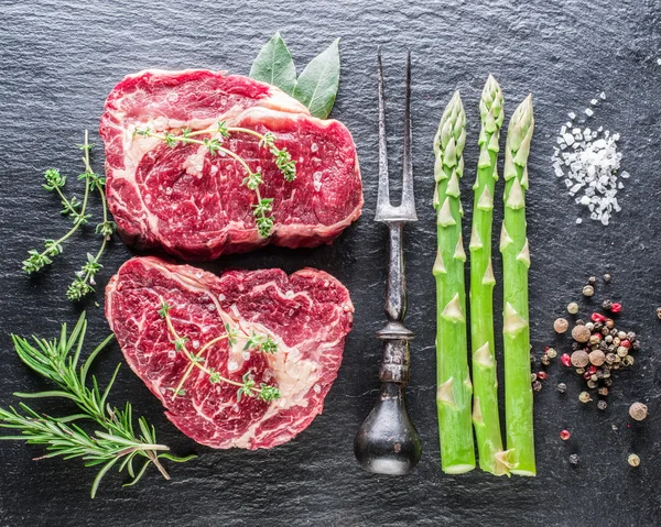 Rib Eye Steak mit Gewürzen auf schwarzem Hintergrund. — Stockfoto