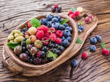 Ripe berries in the wooden bowl. clipart