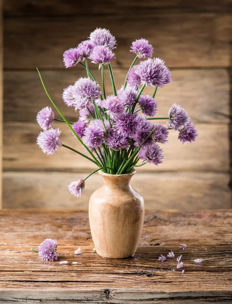 Bukett av lök (gräslök) blommor i vas på trä bordet — Stockfoto