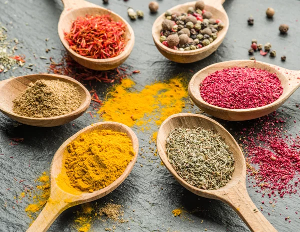 Assortment of colorful spices in the wooden spoons. — Stock Photo, Image