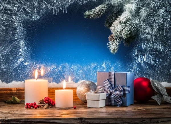 Coffrets cadeaux, lumières de bougie et fenêtre gelée. Backgroun de Noël — Photo