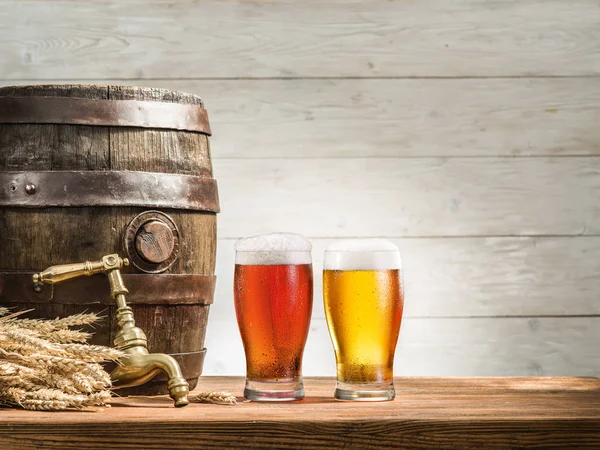 Sklenice piva a piva barel na dřevěný stůl. Brewe řemesla — Stock fotografie
