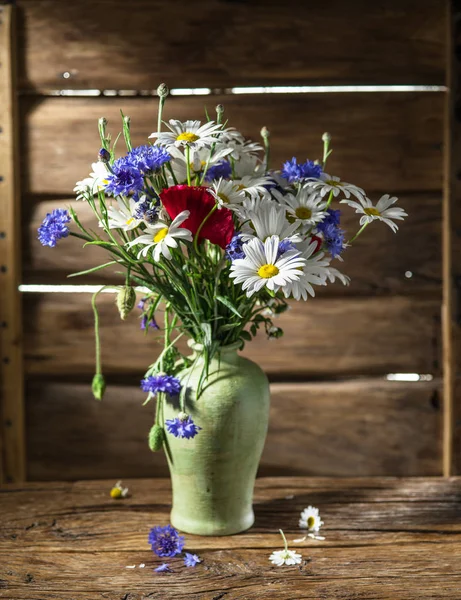 木制的桌子上的花瓶中字段的花束. — 图库照片