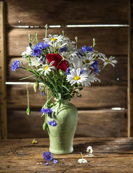 Boeket van veld bloemen in de vaas op de houten tafel. — Stockfoto