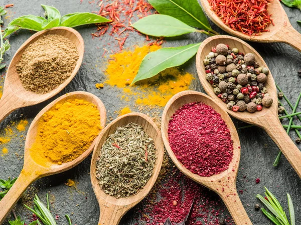 Assortment of colorful spices in the wooden spoons. — Stock Photo, Image