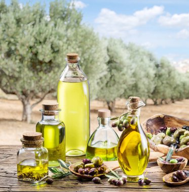 Ahşap masa altında zeytin zeytinyağı ve meyveleri olan tr