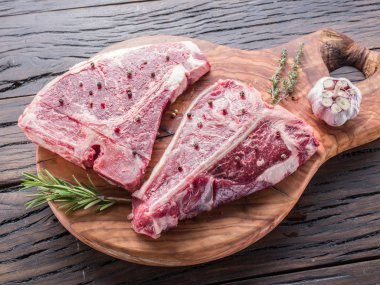 Ahşap kesme tahtası üzerinde baharatlar ile T-bone biftek.