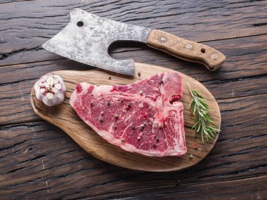 Ahşap kesme tahtası üzerinde baharatlar ile T-bone biftek.
