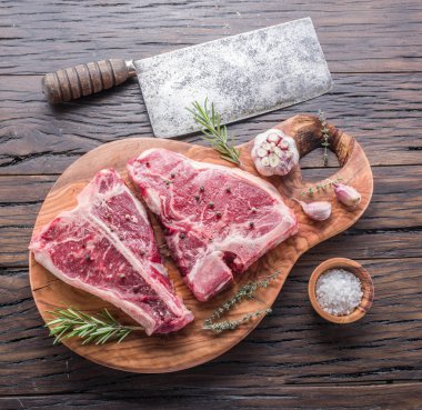 Ahşap kesme tahtası üzerinde baharatlar ile T-bone biftek.