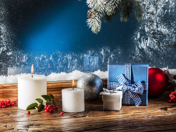 Подарочные коробки, свечи и замороженное окно. Рождественская спинка — стоковое фото