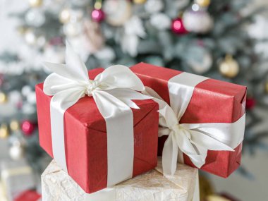 Kırmızı hediye boxex ve arka planda bir şekilde dekore edilmiş yeni yıl ağacı. 