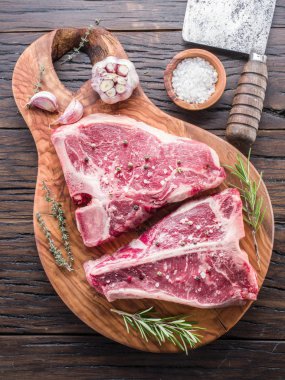 Ahşap kesme tahtası üzerinde baharatlar ile T-bone biftek.