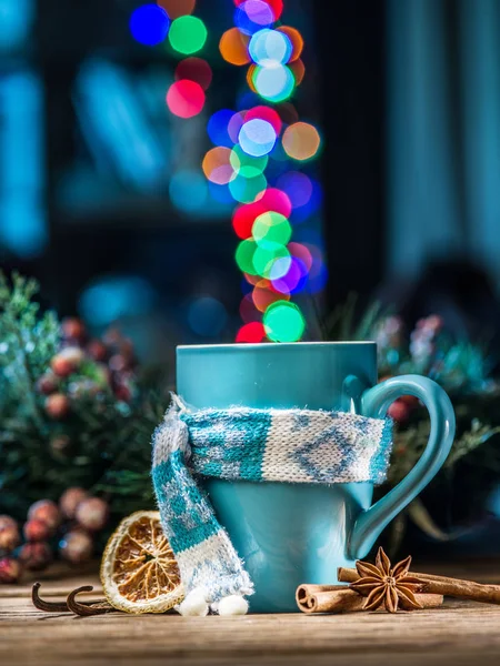 Cup with magic colorful lights and spices. Christmas background.