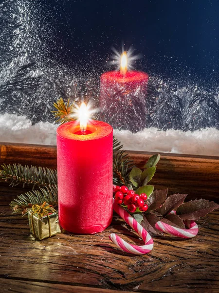 Vela de Natal, ramo de abeto, bengalas doces e janela congelada em b — Fotografia de Stock