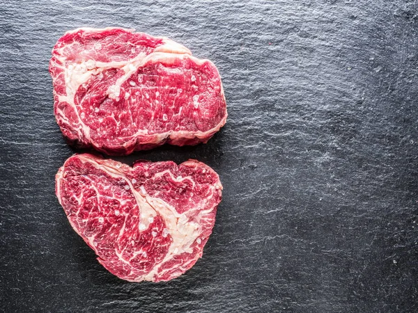 Rib eye steaks on the black background. — Stock Photo, Image