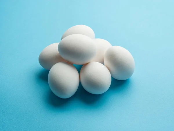 Uova di pollo bianco sullo sfondo blu . — Foto Stock