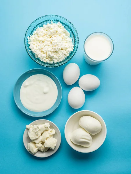 Productos proteicos: queso, nata, leche, huevos sobre el fondo azul — Foto de Stock