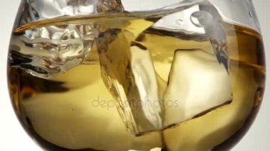 Eksen tarafından cam viski ve buz küpleri ile döner.