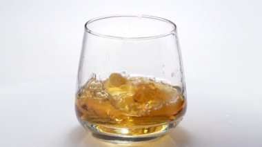 Buzlu cam içine viski döktü. Ağır çekim. 120fps