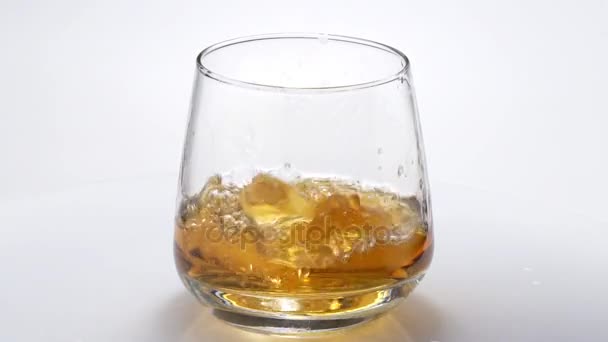 Whiskey in ein Glas mit Eis gegossen. Zeitlupe. 120fps — Stockvideo