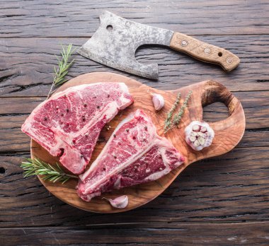 Ahşap kesme tahtası üzerinde baharatlar ile T-bone biftek.