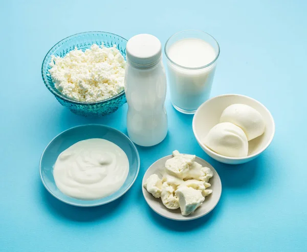 Eiweißprodukte: Käse, Sahne, Milch, Eier auf blauem Hintergrund — Stockfoto