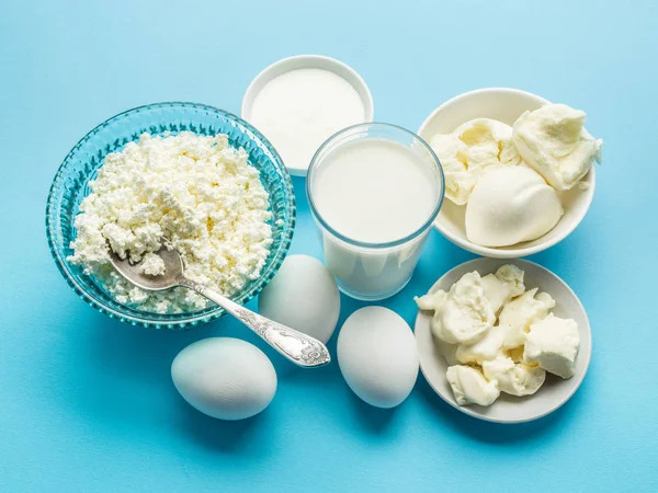 Bílkoviny: sýr, smetana, mléko, vejce na modré poz — Stock fotografie