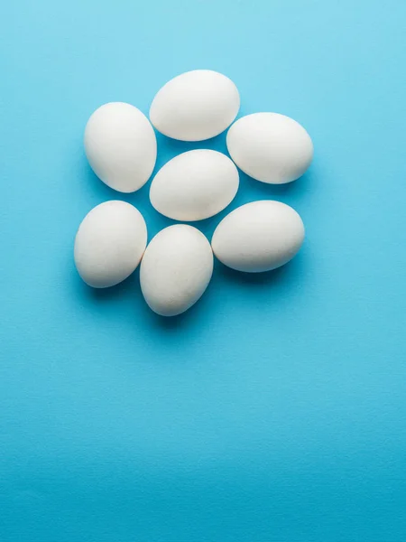 White chicken eggs on the blue background. — Stock Photo, Image